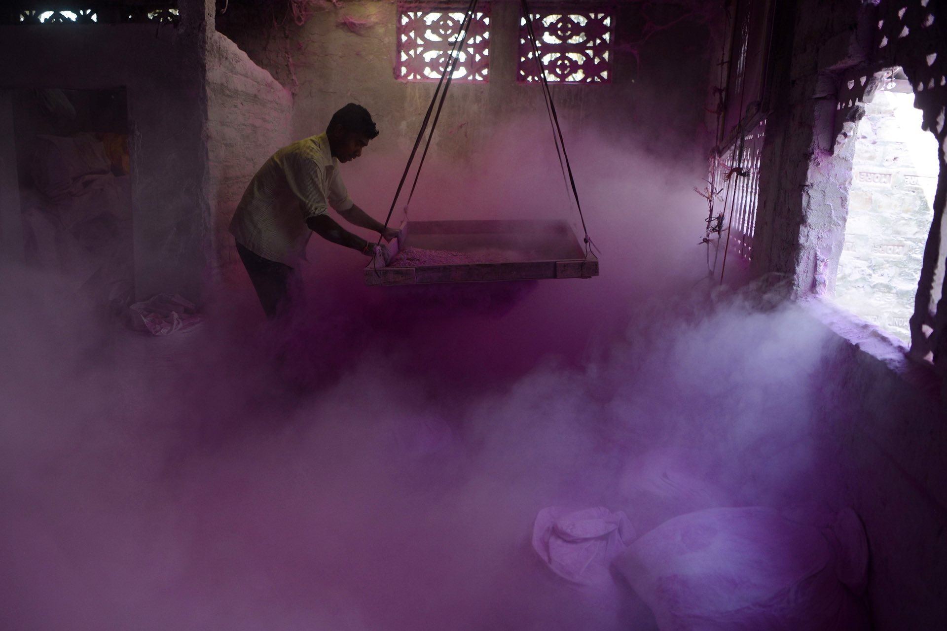A labourer sifts coloured powder, known as gulal, which will be used during the Hindu spring festival of Holi, Siliguri, India. PHOTO: AFP 
