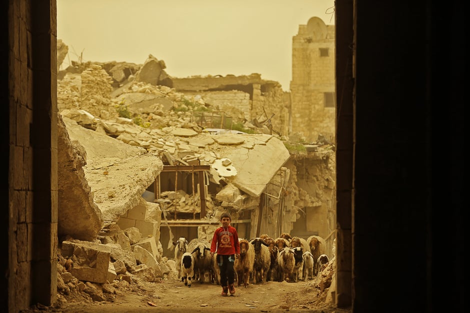 A Syrian boy walks with his sheep through the once rebel-held Bab Kinnisrin neighbourhood in the old part of the northern city of Aleppo during a sandstorm. PHOTO: AFP