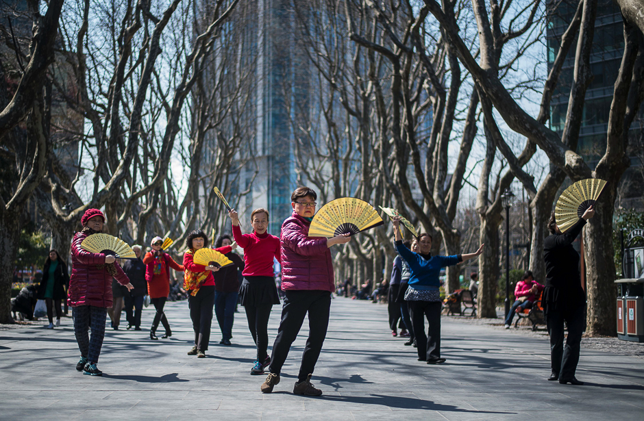 Women dance with fans in a park on a sunny day in Shanghai. PHOTO: AFP
