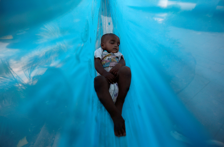 Eleven-month-old Sakeena sleeps in a hammock on the promenade next to a lake in Mumbai, India. PHOTO: REUTERS