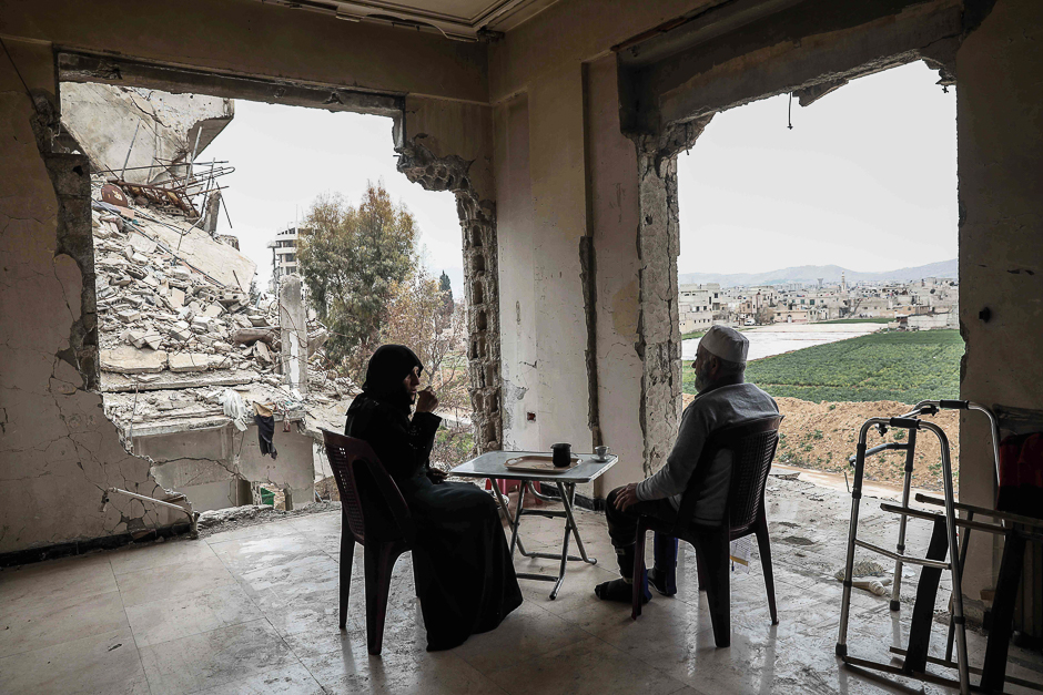 Syrian Umm Mohammed, and her husband drink coffee at their destroyed home in the rebel-held town of Douma, on the outskirts of the capital Damascus. PHOTO: AFP