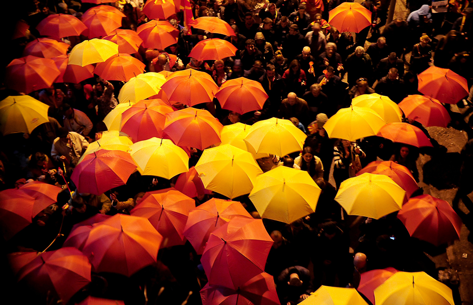Protesters shout slogans while holding red and yellow umbrellas during demonstrations against an agreement that would ensure the wider official use of the Albanian language, in Skopje, Macedonia. PHOTO: REUTERS