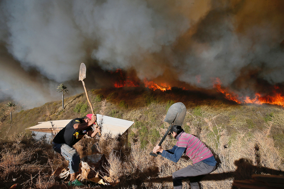 Residents work to prevent a wildfire from spreading to their homes in Vina del Mar, Chile. PHOTO: REUTERS