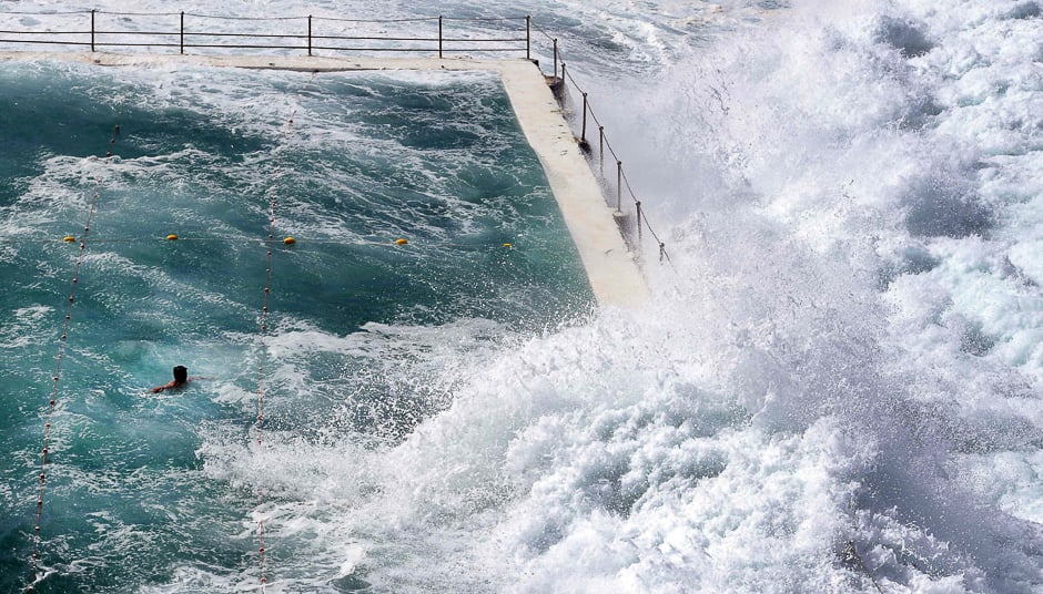 A swimmer at Bondi's ocean pool watches as a big wave pours into the pool as large seas pound the coast at Bondi Beach in Sydney. PHOTO: AFP