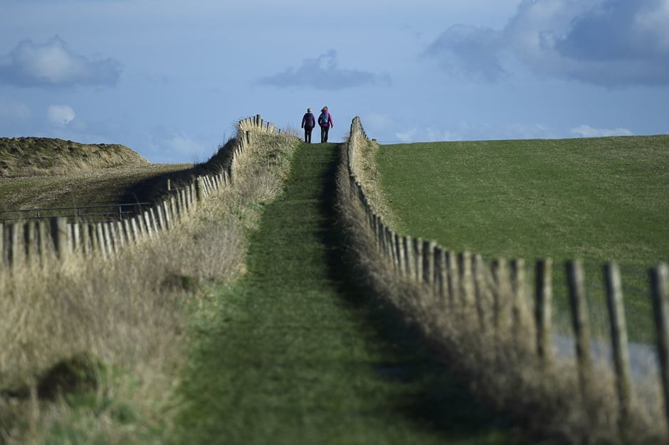 People go for a walk along the Causeway Coastal route in Ballintoy, Northern Ireland. PHOTO: REUTERS