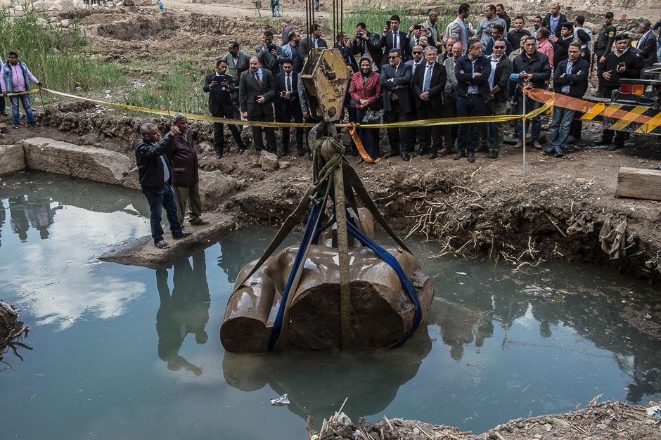 Egyptian workers excavate the statue, recently discovered by a team of German-Egyptian archeologists, in Cairo's Mattarya district. PHOTO: AFP