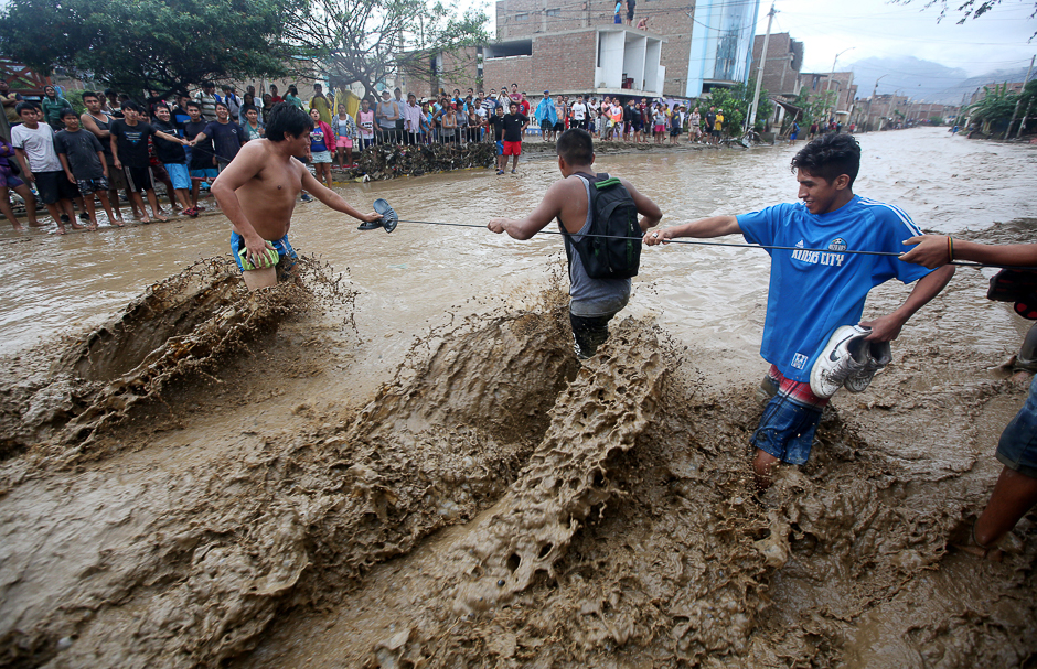 Residents cross a street after a massive landslide and flood in Trujillo, northern Peru. PHOTO: REUTERS