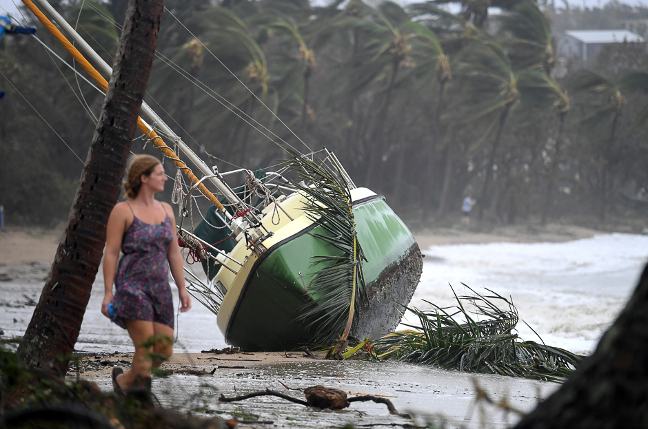 A local resident walks past a yacht that was washed ashore after Cyclone Debbie hit the northern Queensland town of Airlie Beach, located south of Townsville in Australia. PHOTO: REUTERS