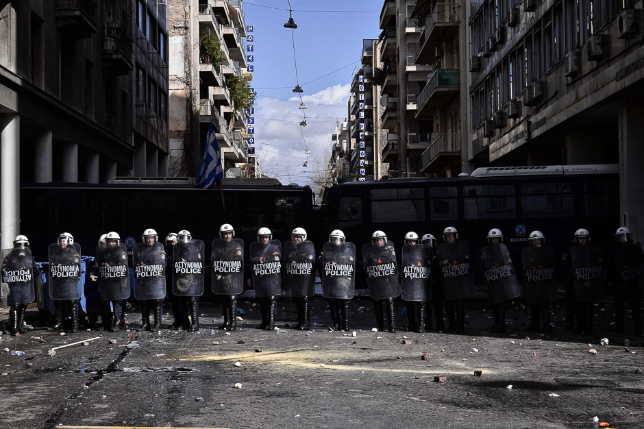 Police stand by a blockade during a Greek farmer's protest against higher taxes outside the Agriculture ministry in Athens. Two people were detained after the windows of two police vans were smashed as approximately 1,000 farmers, mainly from the island of Crete, took part in the protest. PHOTO: AFP