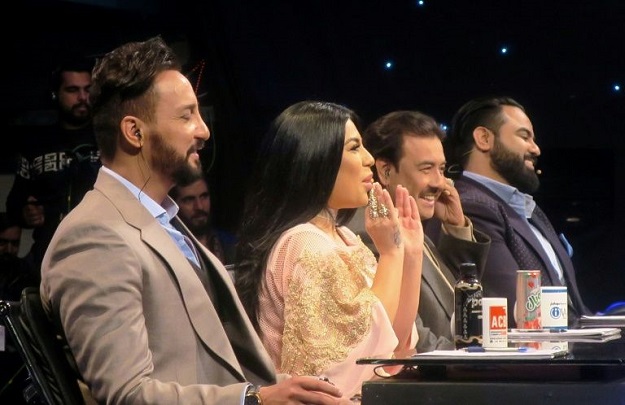 Young Afghan singer Zulala Hashemi performs alongside competitors Sayed Jamal Mubarez (L) and Babak Mohammadi during the television music competition 'Afghan Star', in Kabul. PHOTO: AFP
