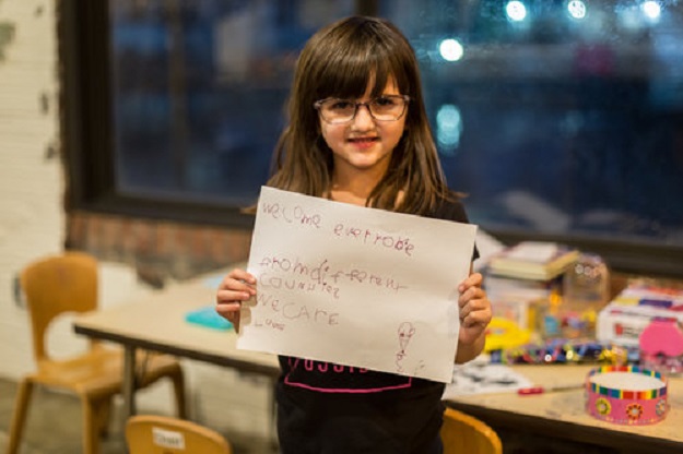 Grace Fetterman, age 5, holds a sign that she created reading a simple, but sincere message: 