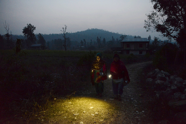 Nepalese women Pabitra Giri (R) and Yum Kumari Giri (L) walk back after dinner to a Chhaupadi hut during their menstruation period in Surkhet District, some 520km west of Kathmandu, February 3, 2017. PHOTO: AFP
