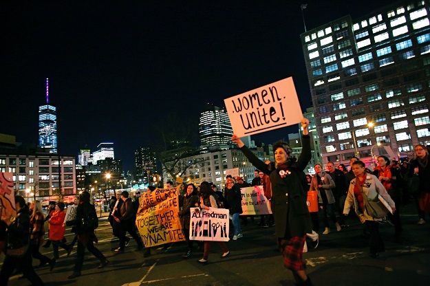 People hold up signs during an International Women's Strike Rally on March 8, 2017 in New York City. PHOTO: AFP