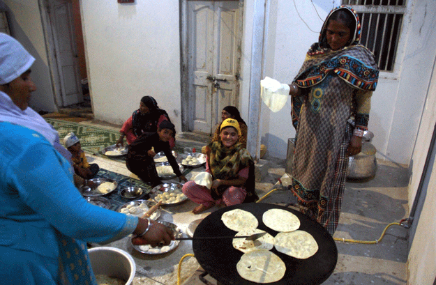 In the courtyard of the gurdwara, women were tasked to prepare the langar [feast distributed free of charge] for the devotees. This is a daily routine but that night it was a bit more special in connection with Baisakhi. PHOTO: ATHAR KHAN