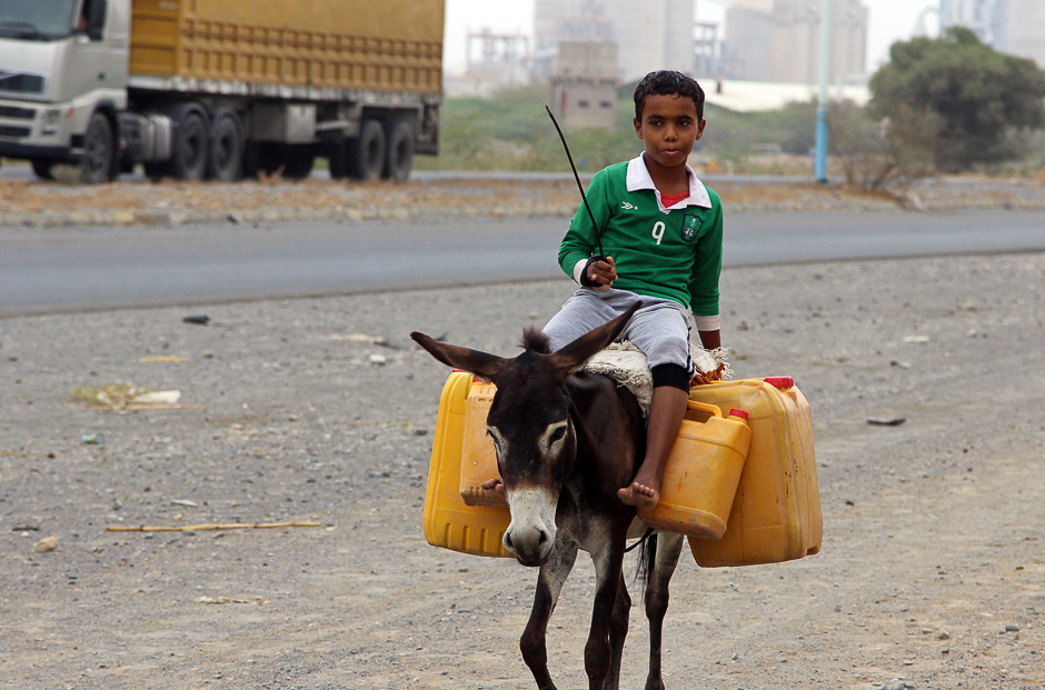 A Yemeni boy rides a donkey carrying plastic containers full of water in an impoverished coastal village on the outskirts of the Yemeni port city of Hodeidah. PHOTO: AFP