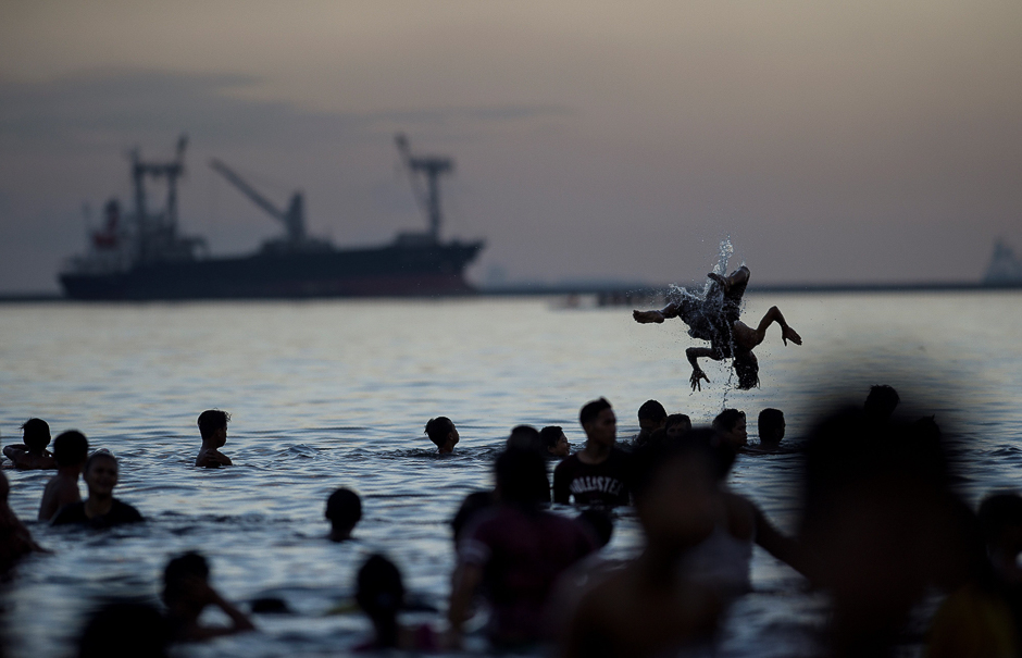 City residents take an Easter Sunday dip in the polluted waters of Manila Bay to beat the scorching heat. PHOTO: AFP