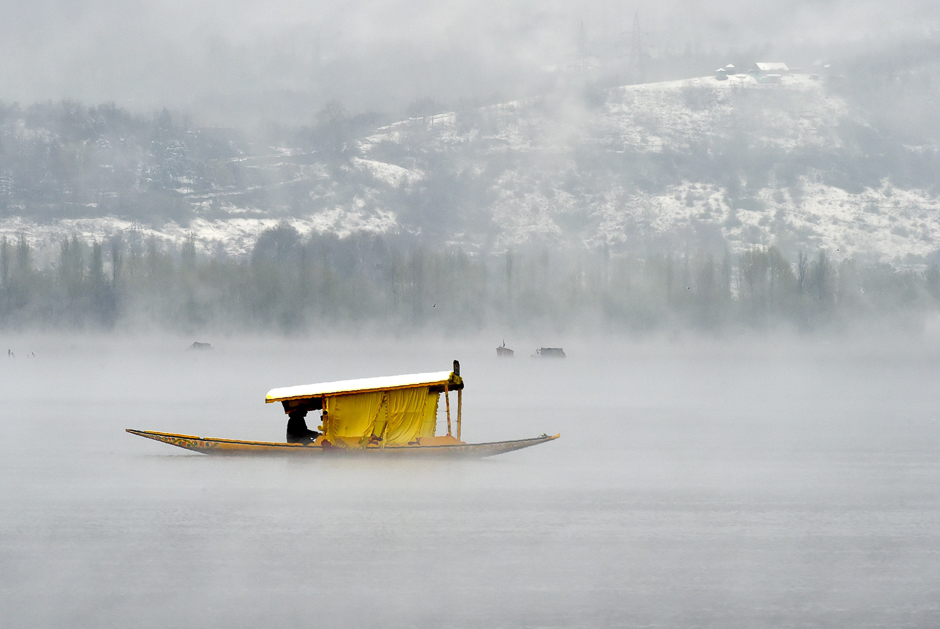 Kashmiri boatmen paddle a shikara across Dal Lake amid dense fog following rainfall in Srinagar. PHOTO: AFP