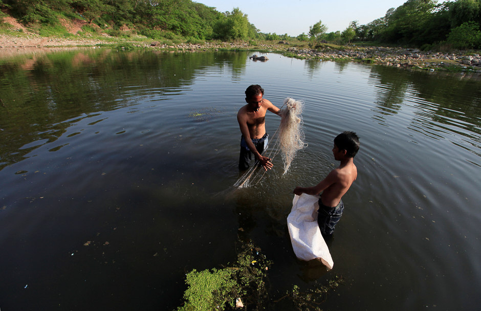 A man casts his net to catch fish in the waters of Rawal Lake in Islamabad, Pakistan. PHOTO: REUTERS