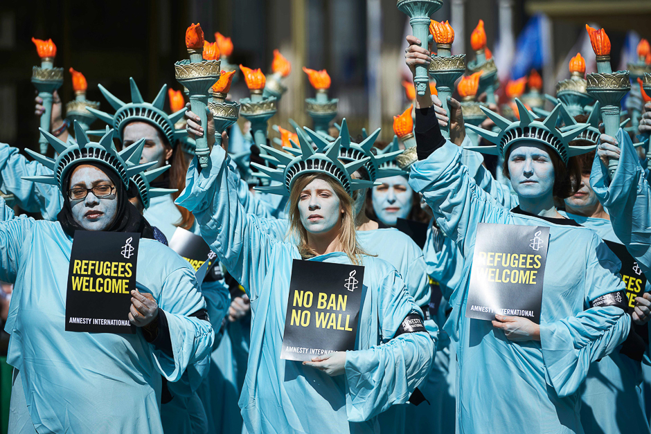 Activists from Amnesty dressed as the Statue of liberty take part in a demonstration to mark the first 100 days in office of US President Donald Trump outside the US Embassy in London. PHOTO: AFP