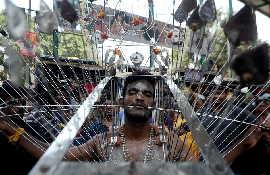 An Indian Hindu devotee, his body pierced with metal skewers, takes part in a procession to mark the Panguni Uthiram festival in Chennai. PHOTO: AFP