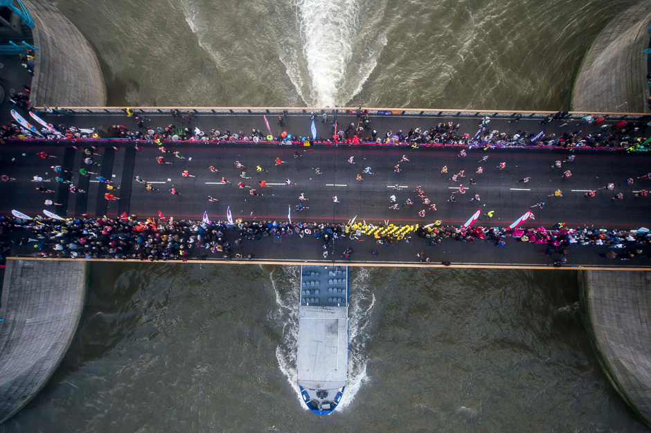 Runners cross the half waypoint on Tower Bridge during the London Marathon in London. PHOTO: AFP