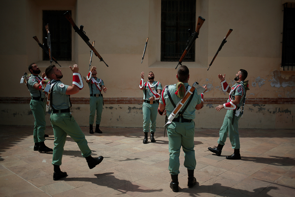Spanish legionnaires throw their weapons in the air as they warm up before taking part in a change of honour guard at the statue of the Christ of Mena during Holy Week in Malaga. PHOTO: REUTERS