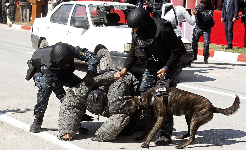 A man acting as a terrorist is attacked by a dog from the canine unit of Tunisia's police during an exercise in the police's barracks in Tunis, Tunisia. PHOTO: REUTERS