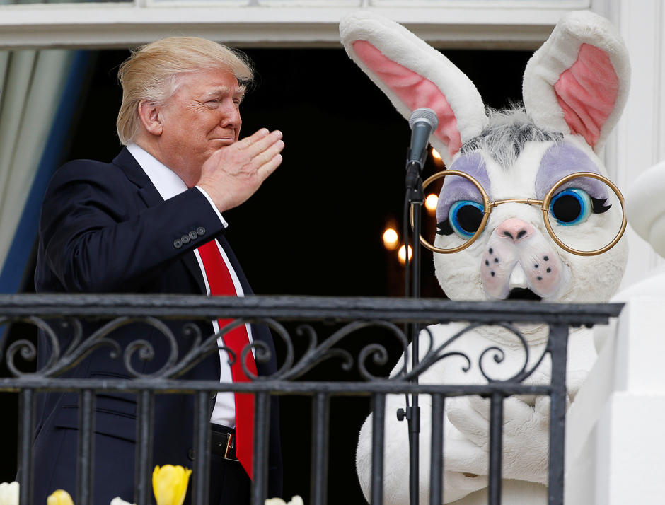 US President Donald Trump salutes a member of the military (not seen in photo) who had just sung the US national anthem as he stands with a performer in an Easter Bunny costume at the White House Easter Egg Roll on the Truman Balcony of the White House in Washington, US. PHOTO: REUTERS