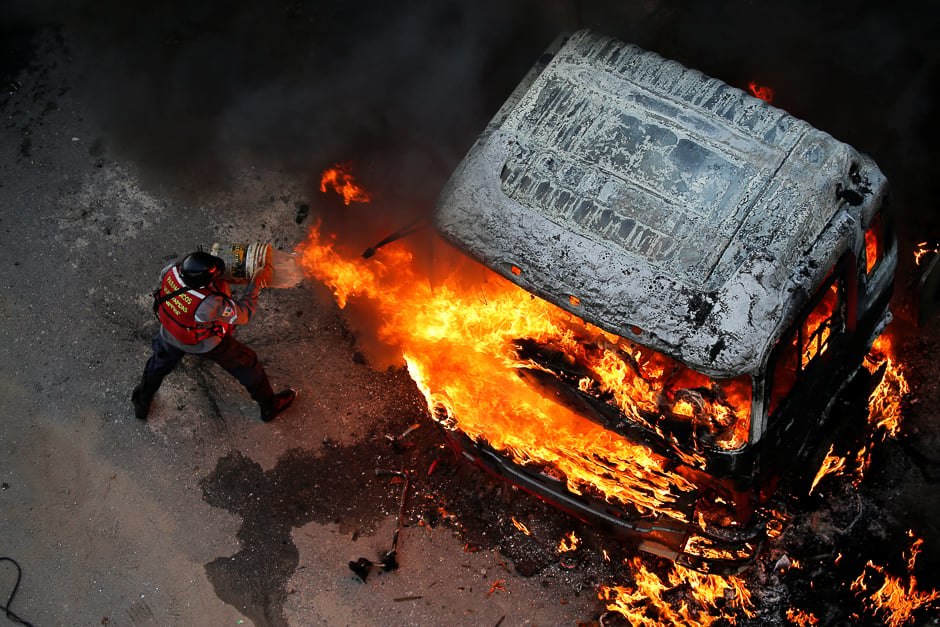 A fireman tries to extinguish a fire during a rally against Venezuela's President Nicolas Maduro in Caracas, Venezuela. PHOTO: REUTERS