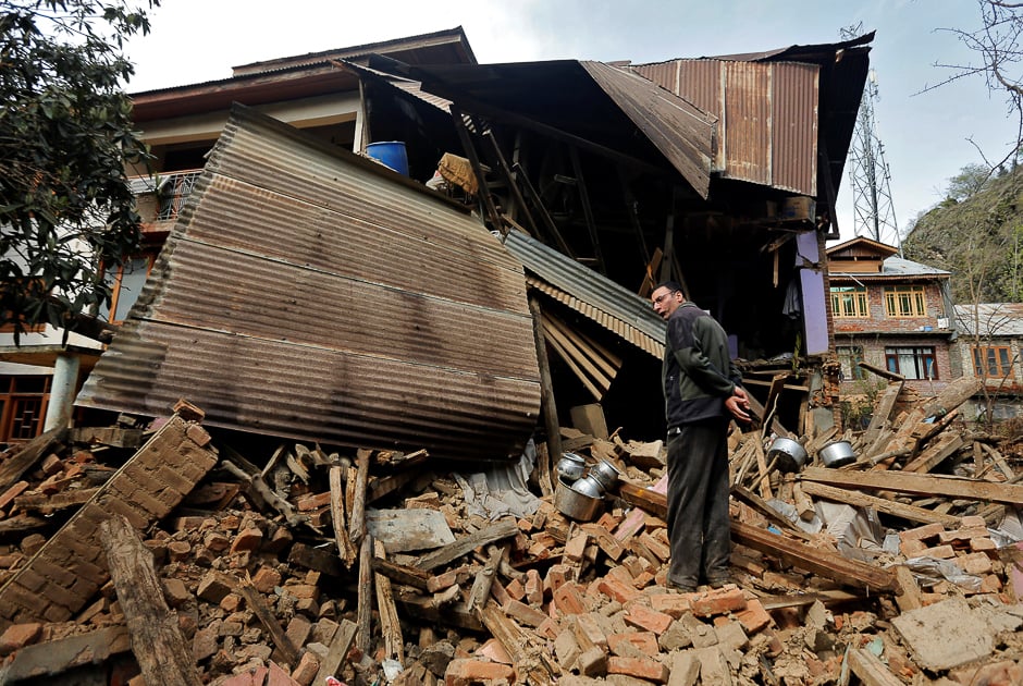A man stands amidst the rubble of a house, which was damaged by incessant rains in Srinagar. PHOTO: REUTERS