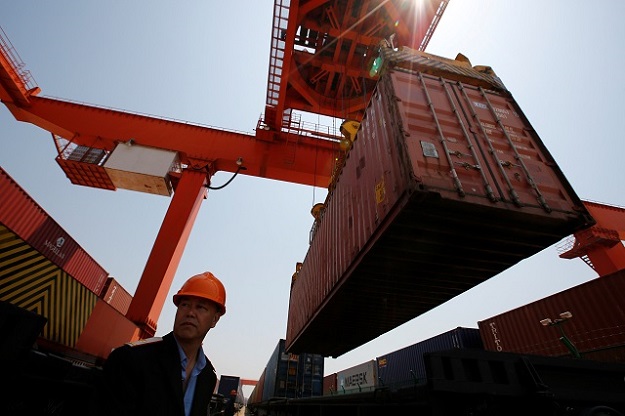 A railway official watches a crane unload containers that arrived from London on the 