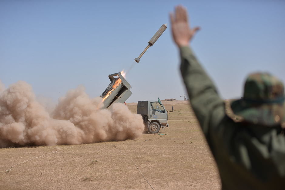 Iraqi paramilitary troops fire towards Islamic State militants during a battle with Islamic State militants on the outskirts of the ancient city of Hatra, south of Mosul, Iraq. PHOTO: REUTERS