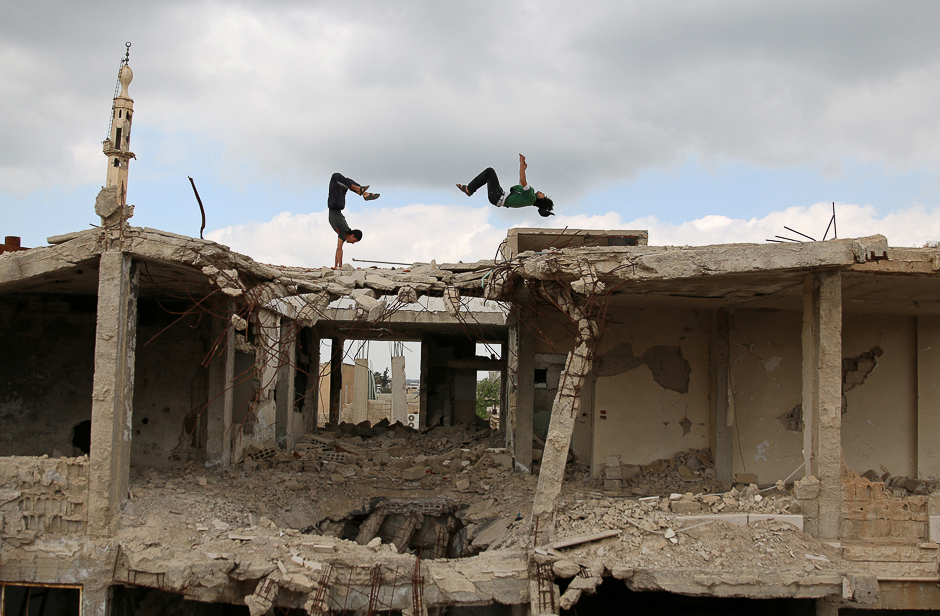 Parkour coach Ibrahim al-Kadiri (R), 19, and Muhannad al-Kadiri, 18, demonstrate their Parkour skills amid damaged buildings in the rebel-held city of Inkhil, west of Deraa, Syria. PHOTO: REUTERS