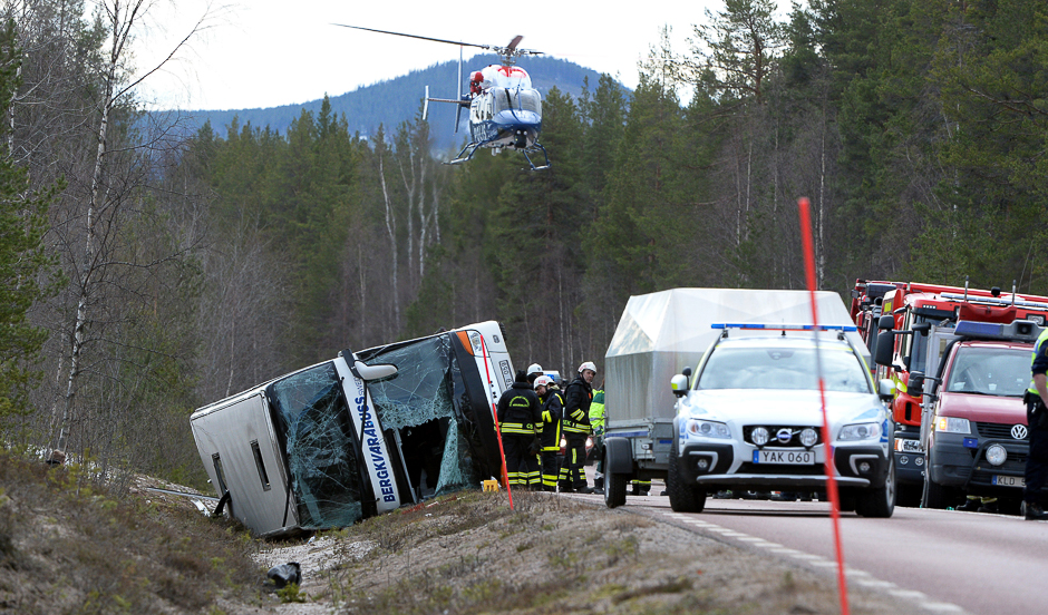 Rescue workers are seen at the site where a bus carrying school children and adults rolled over on a road close to the town of Sveg, in northern Sweden. PHOTO: REUTERS