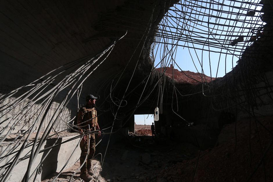 A Syrian Democratic Forces (SDF) fighter inspects a damaged building inside Tabqa military airport after taking control of it from Islamic State fighters, west of Raqqa city, Syria. PHOTO: REUTERS