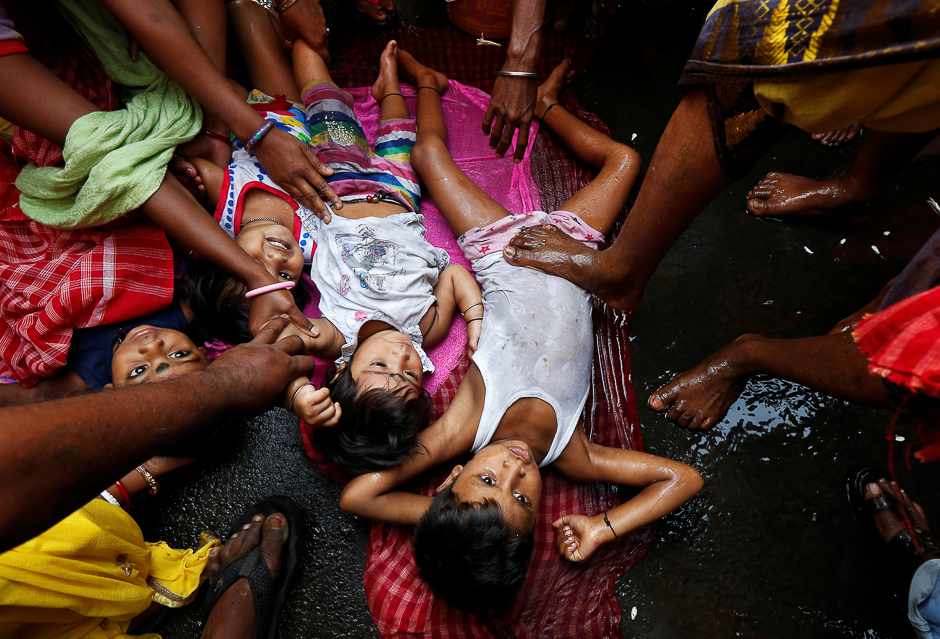 A Hindu holy man (not pictured) touches a child with his feet as part of a ritual to bless him during a religious procession to mark the Gajan festival in Kolkata, India. PHOTO: REUTERS