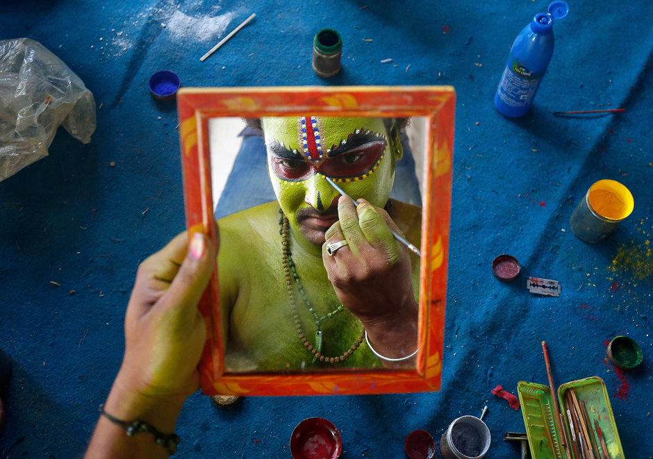 An artiste is reflected in a mirror as he applies make-up backstage before taking part in a celebration to mark Hindu festival of Ramnavami inside the premises of a temple in Bengaluru, India. PHOTO: REUTERS