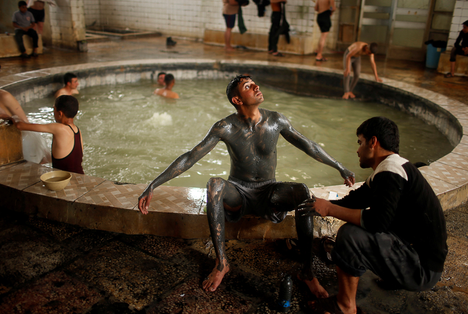 An Iraqi cover his boy with sand from a sulfur pond at Hammam al-Alil city south of Mosul, Iraq. PHOTO: REUTERS