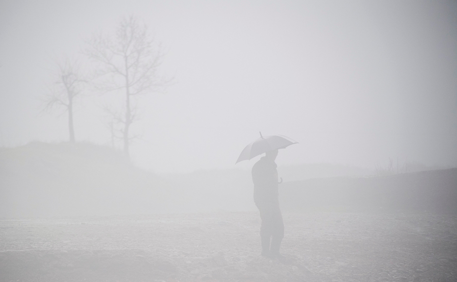 This picture taken shows a North Korean man standing amid fog next to the Yalu river near Sinuiju, opposite the Chinese border city of Dandong. PHOTO: AFP