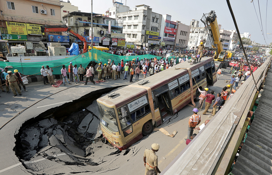 Rescue workers prepare to lift a passenger bus from a pit after a road caved in, in Chennai, India. PHOTO: REUTERS