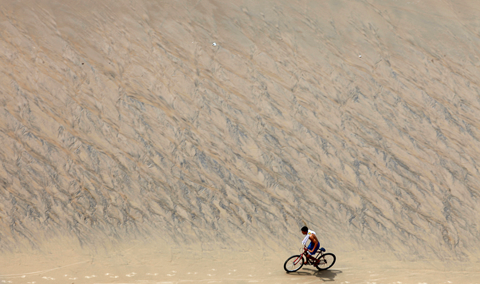 A young man rides a bike on Meireles Beach in Fortaleza, Brazil. PHOTO: REUTERS