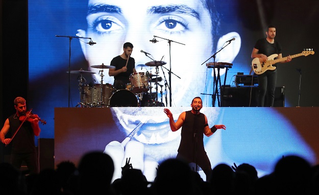 Hamed Sinno (C), the lead singer of Lebanese band Mashrou Leila, performs on stage at the Dubai International Marine Club during a music festival in the United Arab Emirates, on April, 7, 2017. PHOTO: AFP