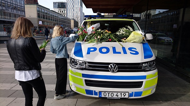  A woman puts flowers on a police vehicle near the Ahlens department store following Friday's attack in central Stockholm, Sweden, April 9, 2017.  PHOTO: REUTERS