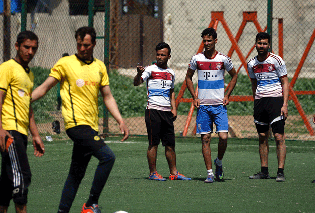 Iraqi players, sporting the jersey of German clubs Bayern Munich (R) and Borussia Dortmund (L), prepare for kick-off during their football match in eastern Mosul's al-Salam neighbourhood on April 7, 2017. PHOTO: AFP