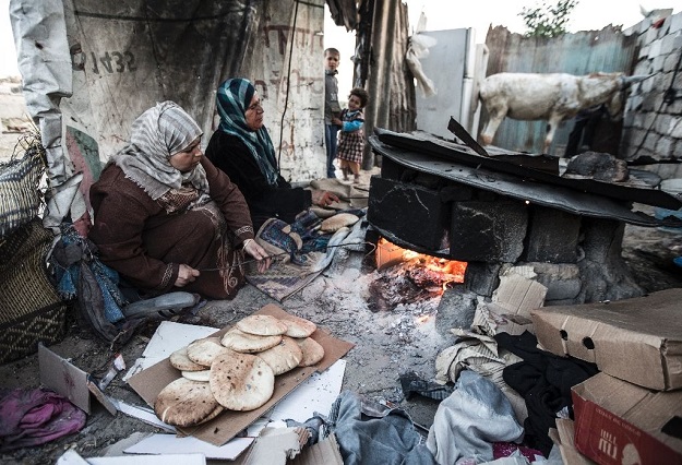 Palestinian women bake bread next to their makeshift home in the Khan Yunis refugee camp in the southern Gaza Strip on April 19, 2017 Palestinian women bake bread next to their makeshift home in the Khan Yunis refugee camp in the southern Gaza Strip on April 19, 2017. PHOTO: AFP