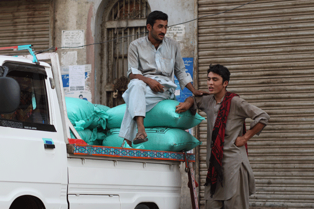 Two labourers indulge in conversation. Labour Day is observed across the world on May 1. PHOTO: FAWAD HASAN