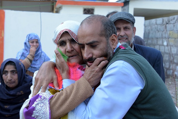 This photograph taken on February 12, 2017, shows Ashiq Hussain (R) greeting his Indian Kashmiri mother Ashraf Jan upon her arrival at her son's house in a refugee camp on the outskirts of Muzaffarabad. PHOTO: AFP