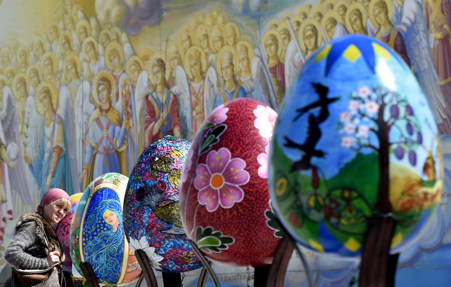 A woman looks at huge Easter eggs as they walk in the open air festival in the centre of Kiev. PHOTO: AFP