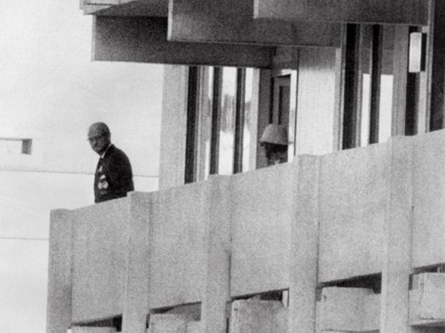 A Palestinian guerrilla member (C) appears on the balcony of the Israeli house watching an official (L) at the Munich Olympic village in 1972 . PHOTO: AFP