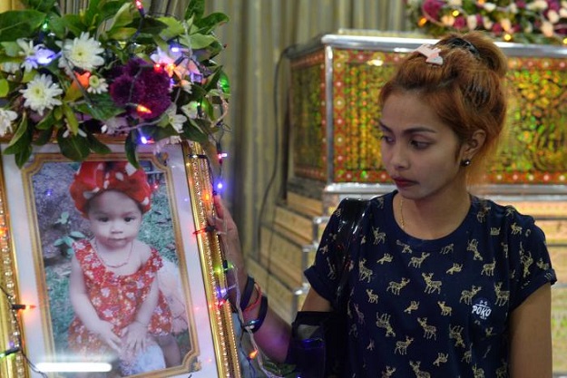 Jiranuch Trirat, mother of 11-month-old daughter who was killed by her father who broadcast the murder on Facebook, stands next to a picture of her daughter at a temple in Phuket, Thailand April 25, 2017. PHOTO: REUTERS